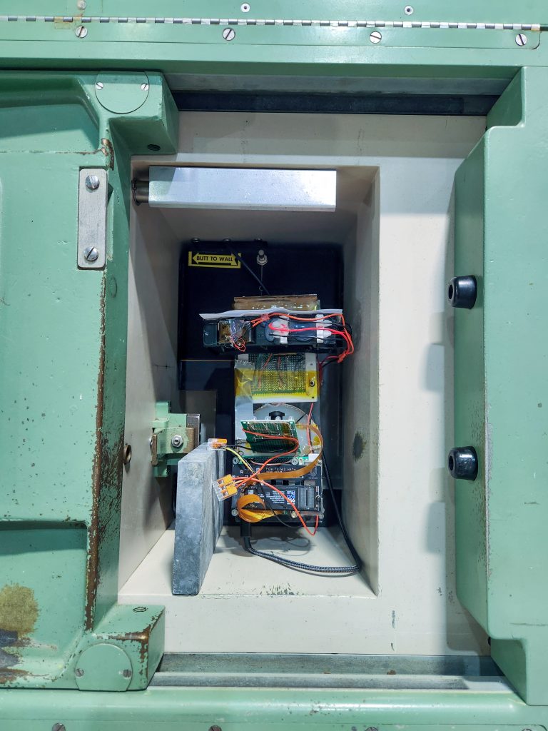A test platform placed inside a roughly shoe-box sized radiation chamber with various electronics on board and a lead block shielding the lower third of the platform from the left.