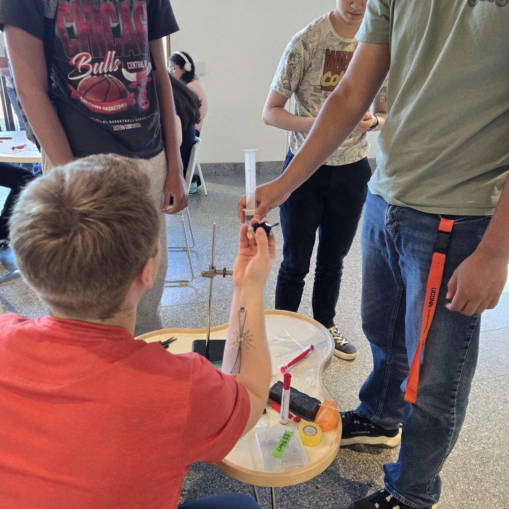 Lab member, Anatol Gogoj in the foreground, demonstrates the manufacturing process of a McKibben actuator.
